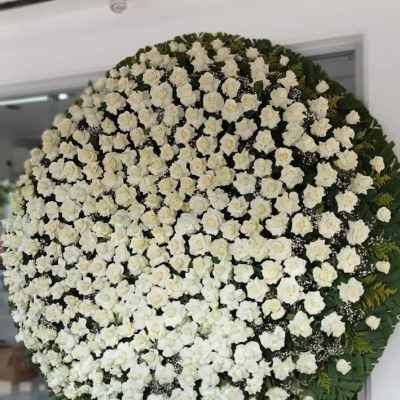 Large circular standing spray of white roses on an easel