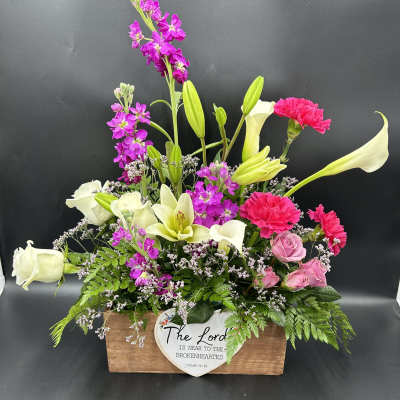 Mixed bouquet in a wooden box with white calla lilies, pink roses, and magenta blooms