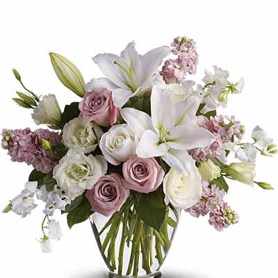 Pink and white bouquet with lilies and roses in a glass vase