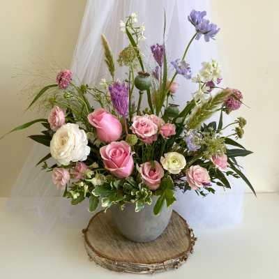 Pink and white roses with purple flowers in a gray vase