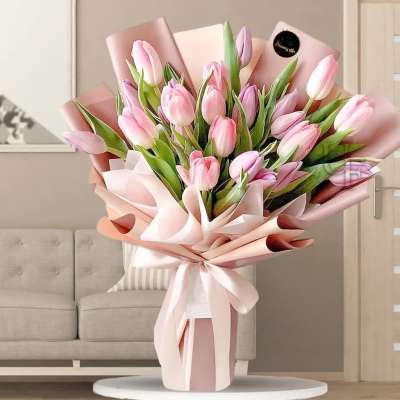 Pink tulip bouquet wrapped in pale pink paper with a ribbon