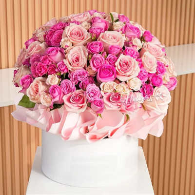 Large bouquet of pink and blush roses in a white round box