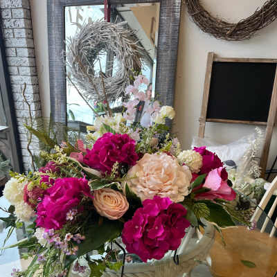 Large mixed bouquet with pink and cream flowers in a white basket