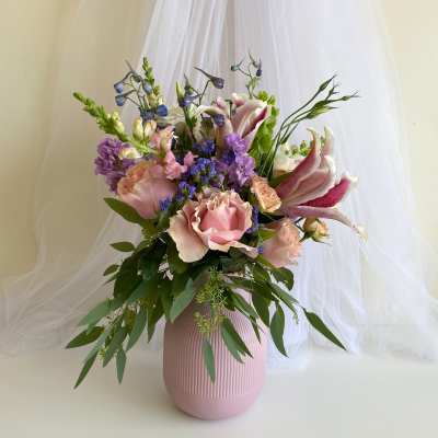 Pink and purple floral arrangement in a ribbed vase