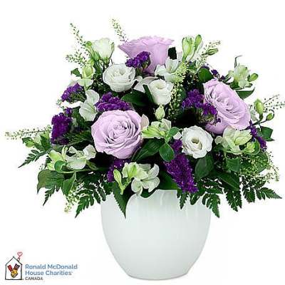 Lavender and white roses arranged in a white vase