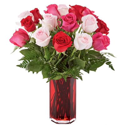 Bouquet of red, pink, and white roses in a red glass vase