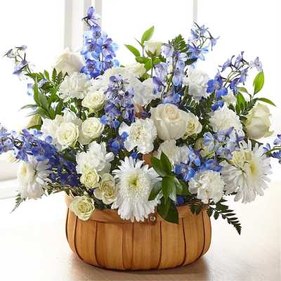White and blue flower arrangement in a wooden basket