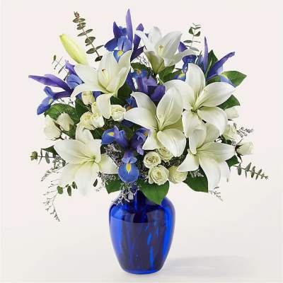 White lilies and blue irises in a cobalt vase