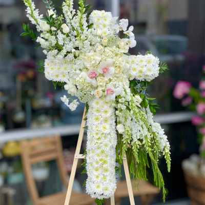 White floral standing spray on an easel with cascading blooms