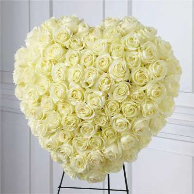 Large heart-shaped bouquet of pale cream roses on a stand