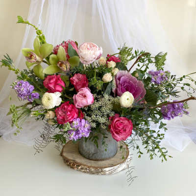 Mixed floral arrangement in a metal vase with pink, purple, white, and green blooms