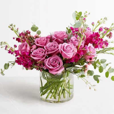Pink rose bouquet in a clear glass vase with airy filler flowers