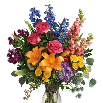 Colorful bouquet with roses, lilies, and snapdragons in a glass vase