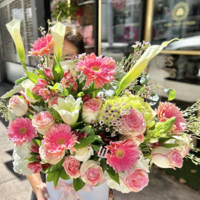 Large pink and white flower arrangement with gerberas, roses and calla lilies in a white hat box