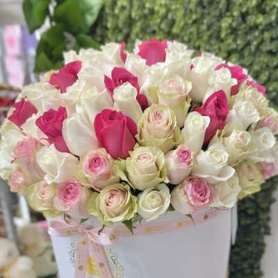 Round hatbox of white, pink, and blush roses tied with a pink ribbon