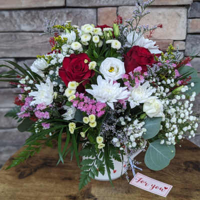 Mixed bouquet of red and white flowers in a white vase