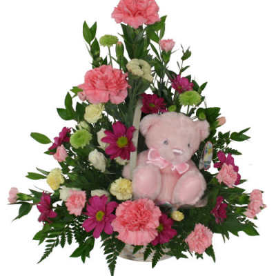 Pink and magenta flower arrangement with a pink teddy bear
