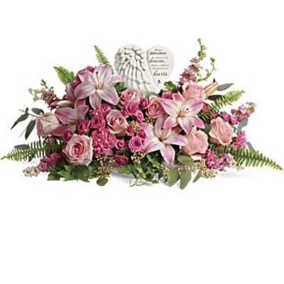 Pink and white floral arrangement with a memorial heart plaque