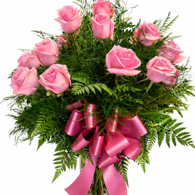 Pink roses in a clear glass vase with a pink ribbon bow