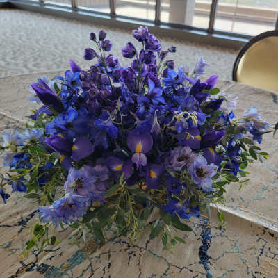 Low bouquet of blue and purple flowers on a table