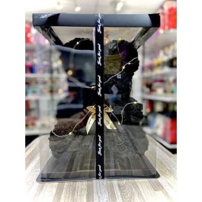 Black rose teddy bear gift in a clear display box with ribbon, lights, and a gold bow.