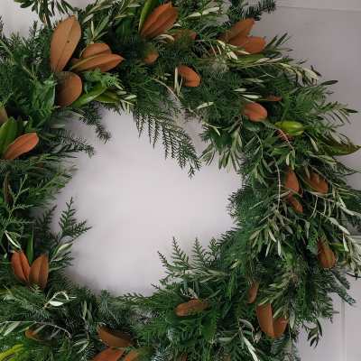 Large green foliage wreath with mixed evergreens and brown-backed leaves