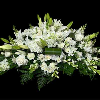 White floral casket spray with lilies and roses