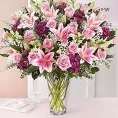 Pink lilies and roses in a clear glass vase