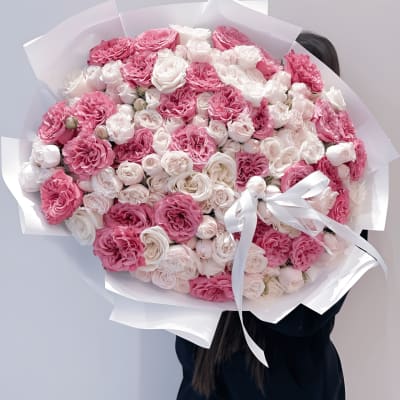 Large bouquet of pink and white roses wrapped in white paper