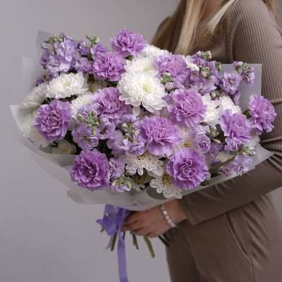 Bouquet of purple and white flowers wrapped in pale paper