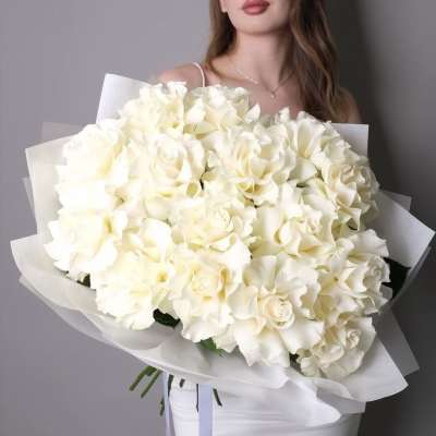 Large bouquet of white roses wrapped in white paper