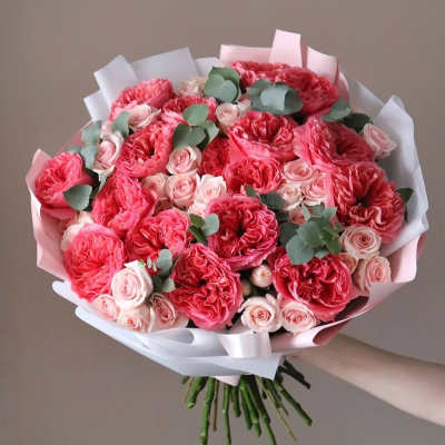 Bouquet of pink roses and eucalyptus wrapped in white paper