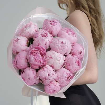 Bouquet of pink peonies wrapped in pale paper