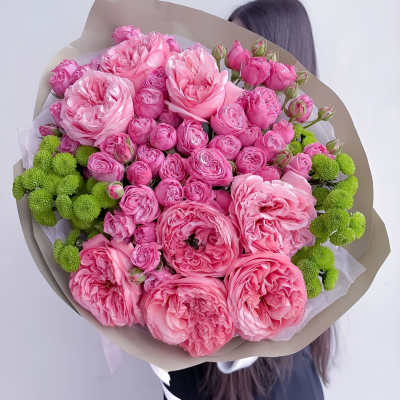 Large bouquet of pink roses with green button mums wrapped in paper