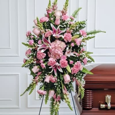 Pink funeral spray beside a casket