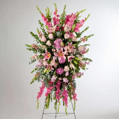 Tall pink and white standing spray with lilies, roses, and hydrangeas on a metal easel