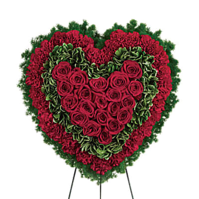 Heart-shaped standing spray of red roses and carnations with green carnations on an easel