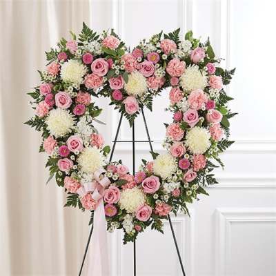 Heart-shaped standing wreath of pink and white flowers on a metal easel