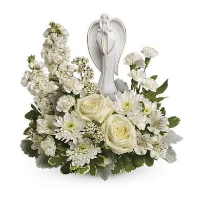 White angel figurine surrounded by white roses, carnations, and other flowers in a low arrangement