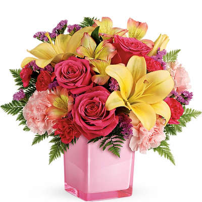 Pink roses and yellow lilies in a pink glass vase