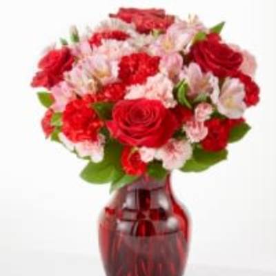 Red and pink mixed bouquet in a red glass vase