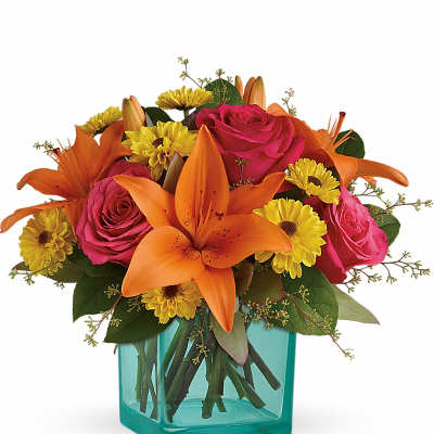 Bouquet of orange lilies, pink roses, and yellow daisies in a turquoise vase