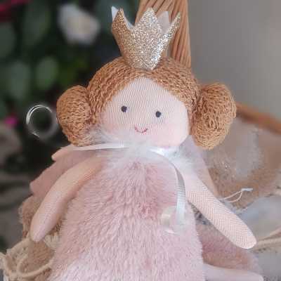 Plush angel doll with a glitter crown in a wicker basket