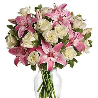 Pink lilies and white roses in a clear glass vase