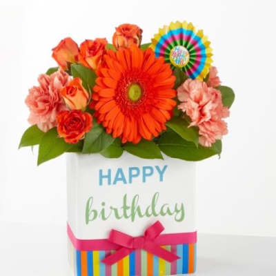 Birthday flower arrangement in a gift box with orange and pink blooms