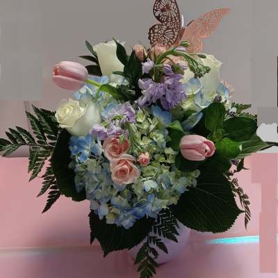 Pastel flower arrangement with roses, hydrangeas, and tulips in a vase