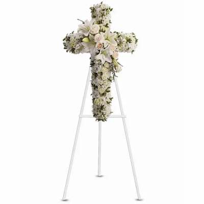 White floral cross arrangement on a stand with lilies and roses