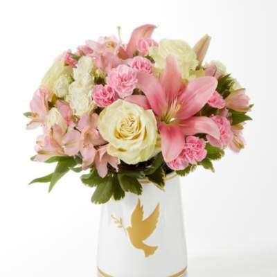 Pink and cream bouquet in a white vase with a gold dove design