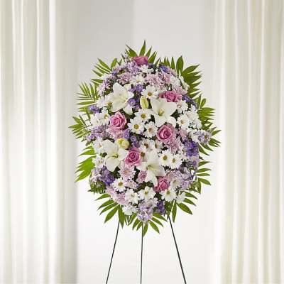 Standing floral spray with white lilies, pink roses, and purple daisies