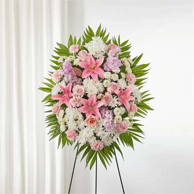 Standing floral wreath with pink and white flowers on a black easel